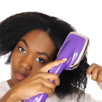 Mujer secando y alaciando su cabello rizado con el cepillo de aire Royale 3 en 1 morado